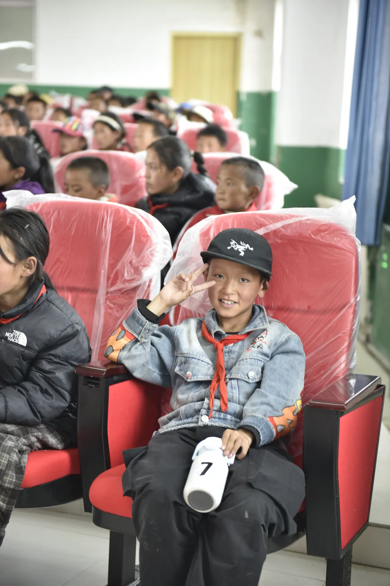 会场中微笑挥手的少年